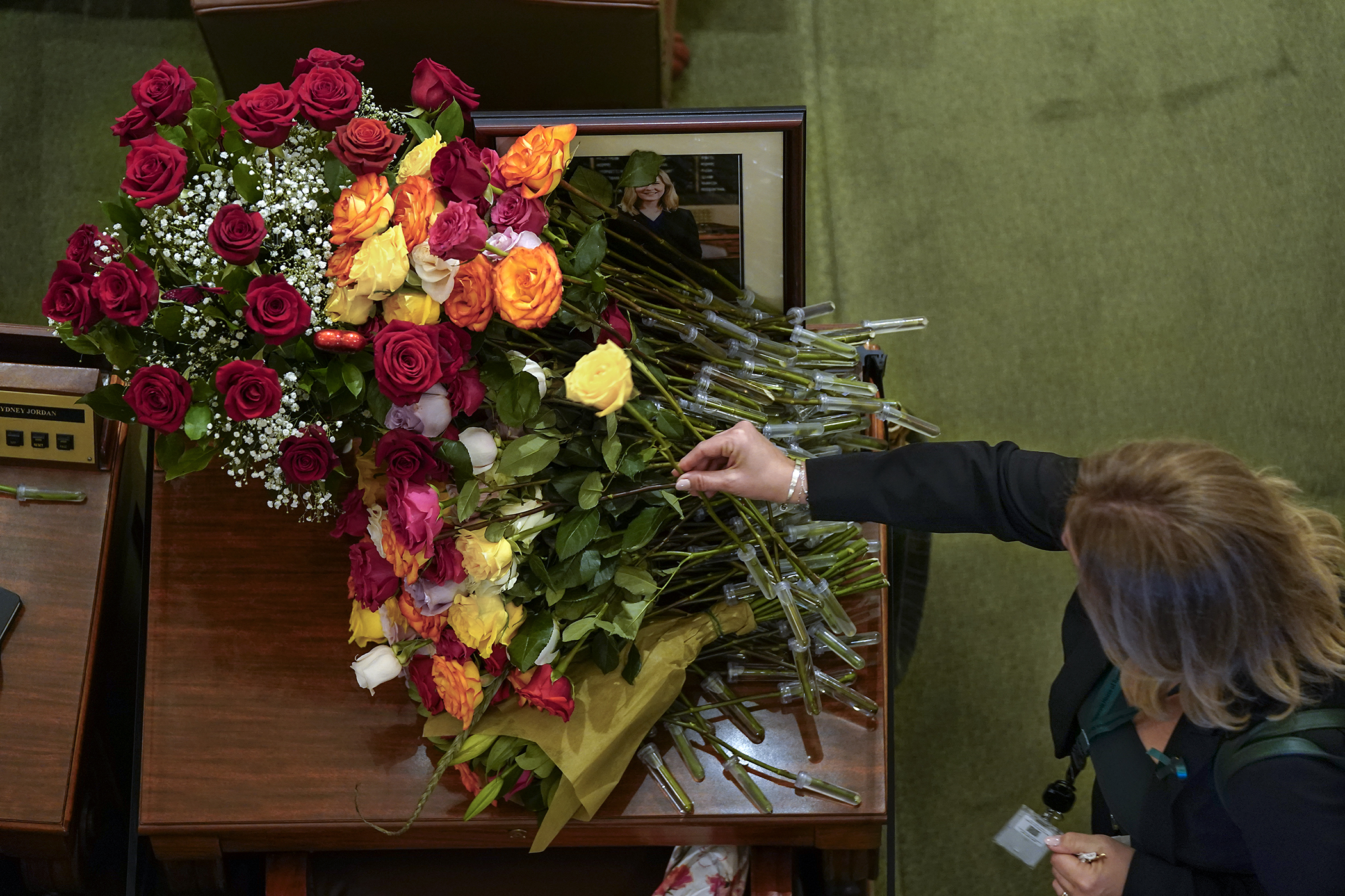 Rep. Julie Greene places a rose on late Speaker Emerita Melissa Hortman’s desk Feb. 17 following a remembrance honoring the former DFL leader, her husband, Mark, and their dog, Gilbert. (Photo by Mic